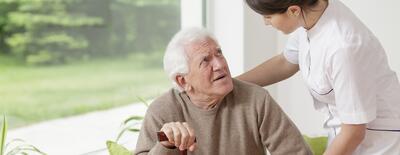 Bild vergrößern: Nurse helping senior man in rest home