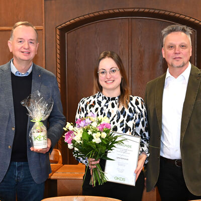 Ehrung für die 4000. Schulungsmitarbeiterin: Lena Schmidt (Mitte) mit Oberbürgermeister Thomas Deffner (links) und Rainer Mattern von der GKDS.