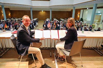 Bild vergr��ern: Feierliche Stadtratssitzung zum 60-j�hrigen Jubil�um der St�dtepartnerschaft zwischen Bay City und Ansbach, v. l. Oberb�rgermeister Thomas Deffner mit der damaligen Citymanagerin Dana Muscott